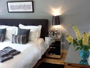 a bedroom with a bed with a vase of flowers at Flat 4 Summertown Court in Oxford