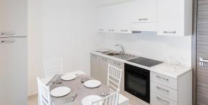 a kitchen with a table with chairs and a sink at L'Incanto di Paestum in Capaccio-Paestum