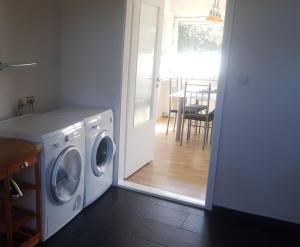 a laundry room with a washing machine and a dining room at Haus Hölderlin in Wilhelmshaven