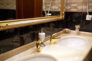 
a bathroom sink with a mirror and a soap dispenser at Aeton Melathron Hotel in Tríkala
