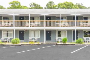 a large building with white chairs and a parking lot at Ocean Park Inn Cape Cod in Eastham