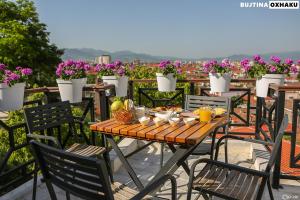 a table and chairs on a balcony with flowers at Bujtina Oxhaku in Korçë