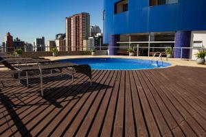 a deck with benches and a pool on a building at Bristol Brasil 500 Curitiba Batel in Curitiba