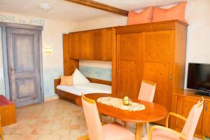a small room with a table and a bed and a television at Hotel Casa Rustica - Eintrittskarten für den Europapark erhalten Sie garantiert über uns! in Rust