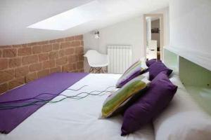 a bedroom with a large white bed with purple pillows at Apartamentos Turísticos Beethoven Haro in Haro