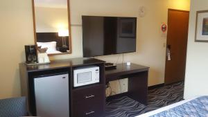 una camera d'albergo con TV e scrivania con forno a microonde di Tradewinds Motel a Rockaway Beach