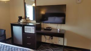 a hotel room with a microwave and a television at Tradewinds Motel in Rockaway Beach