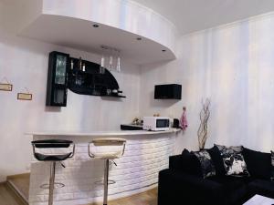 uma sala de estar com um bar e um sofá em AIA Apartment em Kutaisi