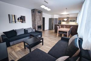 a living room with a couch and a table and a kitchen at Penzion Kratochvíl in Dolní Dunajovice