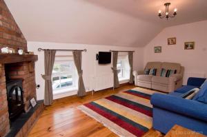 a living room with a blue couch and a fireplace at Hillcrest Cottage in Carrickfergus