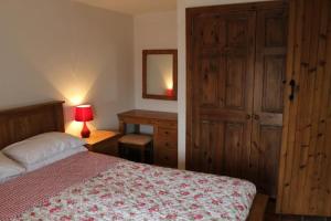 1 dormitorio con cama, escritorio y espejo en Hillcrest Cottage en Carrickfergus