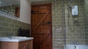 a bathroom with a wooden door and a sink and a shower at Hillcrest Cottage in Carrickfergus +55 photos