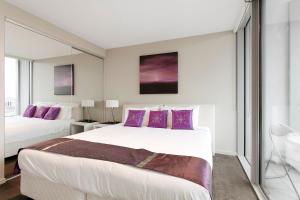 a bedroom with two beds and purple pillows at Docklands Private Collection - NEWQUAY in Melbourne
