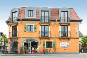 un bâtiment orange avec des fenêtres et des balcons dans une rue dans l'établissement Hotel Casa Rustica - Eintrittskarten für den Europapark erhalten Sie garantiert über uns!, à Rust