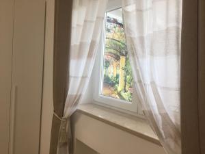 a window with a curtain on a window sill at La Primavera in Anacapri