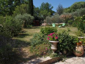 einen Garten mit Blumen und Pflanzen im Hof in der Unterkunft Une Heure Bleue in Manosque