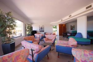 a waiting room with colorful chairs and tables at Hotel Residence Isola Verde in Marciana Marina