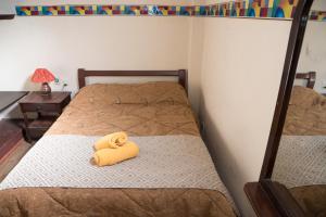 a yellow towel sitting on a bed in a room at Hotel Flor de Oriente in Baños