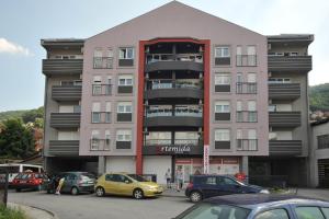 un edificio alto con coches estacionados frente a él en Apartment Exclusive, en Užice