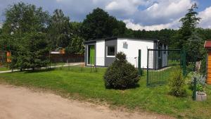 a tiny house in a yard with a fence at Kranichnest in Rheinsberg