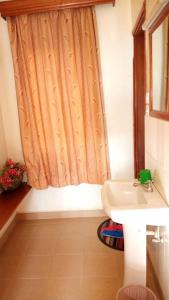 a bathroom with a sink and a shower curtain at Kanberra Hotel in Lira