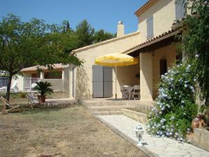 a house with a patio and an umbrella at B&B L'Oustalet de Sylvie in Villeneuve-lès-Avignon