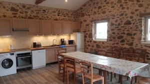 eine Küche mit Tisch und Stühlen in einem Zimmer in der Unterkunft Le Beugnon in La Pommeraie-sur-Sèvre