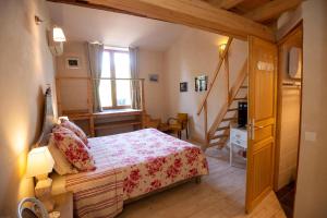 a small bedroom with a bed and a staircase at Les Chambres d'hotes de Laurette in Bertrambois