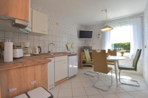 a kitchen with a table and a table and chairs at Ferienhaus "Am Eisenberg"- Wandern im UNESCO Biosphärenreservat Vessertal in Schmiedefeld am Rennsteig