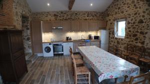 eine Küche mit Tisch und Stühlen in einem Zimmer in der Unterkunft Le Beugnon in La Pommeraie-sur-Sèvre + 20 Fotos
