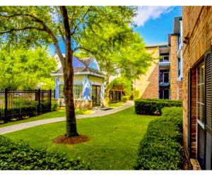 Ein Baum in einem Hof neben einem Gebäude in der Unterkunft The Reside Fully Furnished Condos - Medical Stays Welcome in Houston