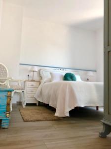 1 dormitorio con cama blanca y vestidor en Apartamentos Turísticos Casa Dina, en Rinlo