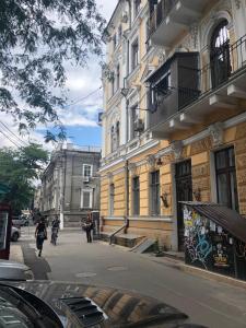 a person riding a bike down a street next to a building at Трёхуровневая квартира у моря in Odesa