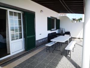 a patio with a table and chairs and a door at Casa da Adega in Ribeira Chã