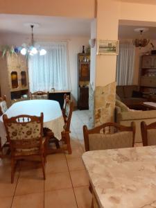 a dining room and living room with a table and chairs at Fejérvári Vendégház in Hajdúszoboszló