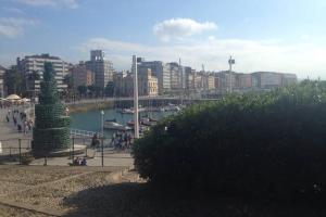 una ciudad con una masa de agua y edificios en Vicaria, en Gijón