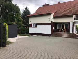 a white house with a red roof and a driveway at Apartamenty sandomierskie GIMO in Sandomierz