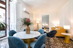 sala de estar con mesa, sillas y sofá en Gran Vía Luxury 3BR, en Granada