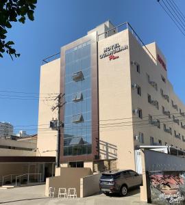 um edifício com um carro estacionado em frente em Hotel Guarumar no Guarujá