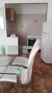 uma cozinha com uma mesa de vidro e um frigorífico branco em Villa Rita em Peschici