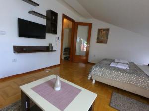 a room with a bed and a table and a tv at Apartman ZENIT in Vrnjačka Banja