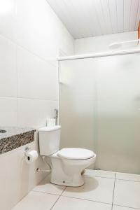 a bathroom with a toilet and a glass shower at Tokyo Hotel in Três Lagoas