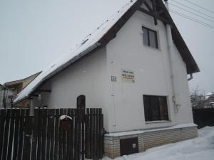a white house with a fence in the snow at Privat Lucia in Nová Lesná