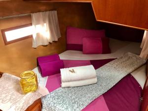 a small bedroom with two beds with purple and white sheets at Sleep & Boats Barcelona City in Barcelona