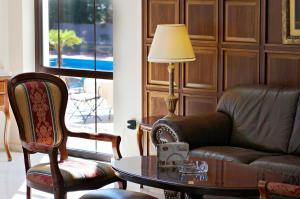 - un salon avec un canapé, une table et une lampe dans l'établissement Aeton Melathron Hotel, à Tríkala
