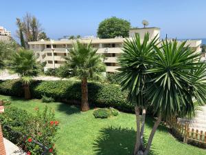 ein großes Apartmenthaus mit Palmen im Hof in der Unterkunft Apartamentai in Torremolinos