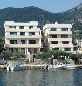 un gran edificio blanco con barcos en el agua en Tondo en Tivat