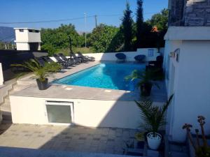 ein Swimmingpool mit Liegestühlen auf einer Terrasse in der Unterkunft Villa Infinity in Krk