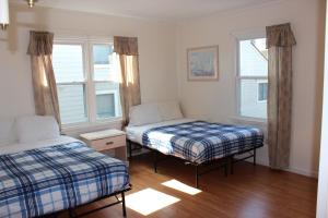 a bedroom with two beds and two windows at Blue Haven Apartments in Ocean City