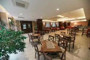 an empty restaurant with wooden tables and chairs at Hotel Kacinari in Prizren